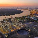 Ukraine’s Drones Are Hitting Russia’s Oil Lifeline Industrial oil refinery complex beside a river at dusk
