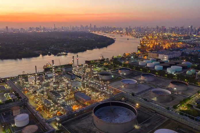 shutterstock_1599038092 Industrial oil refinery complex beside a river at dusk