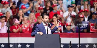 Speaker at podium addressing a rally crowd