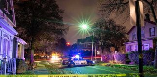Police Shooting of College Athlete Under Investigation Police car blocks residential street at night behind caution tape