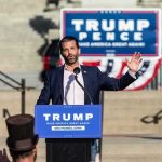 Trump Backs James’ GOP Challenger man speaking at a political rally podium