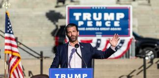 Trump Backs James’ GOP Challenger man speaking at a political rally podium