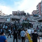 Rescue workers and civilians on collapsed building after earthquake