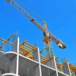 Tower crane over concrete building under construction