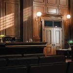 Insider Heist: Seniors Hit Twice Empty courtroom interior with wooden judge's bench and double doors