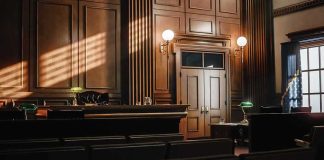 Empty courtroom interior with wooden judge's bench and double doors