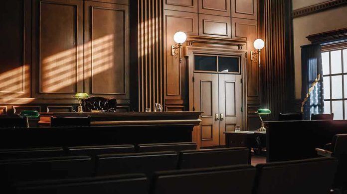 shutterstock_2056420763 Empty courtroom interior with wooden judge's bench and double doors