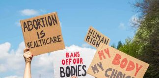 Massachusetts Ends 24-Week Abortion Limit Protesters hold cardboard signs at a rally outdoors