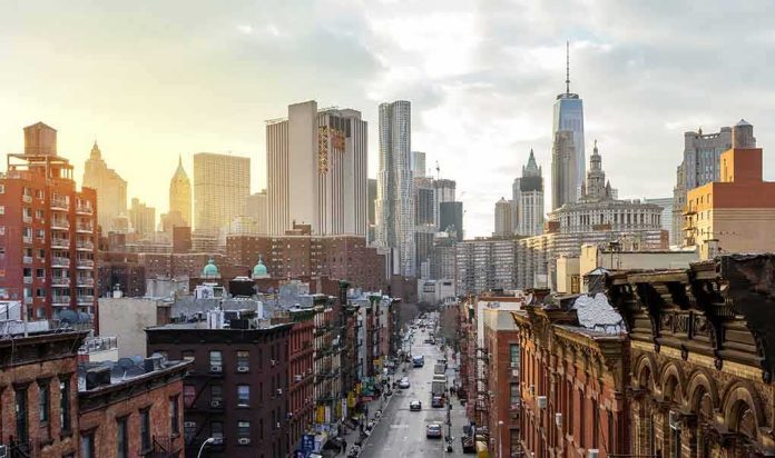 City street leading to a skyline of modern and historic skyscrapers at sunset