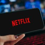 Smartphone displaying Netflix logo held in hand