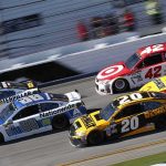 Stock cars racing side by side on a banked track