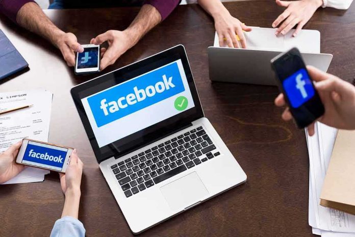shutterstock_641039665 Laptop with Facebook on screen surrounded by smartphones