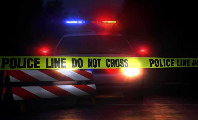 Police car behind crime scene tape at night