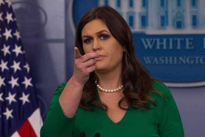 shutterstock_744405085 woman at podium pointing forward during press briefing