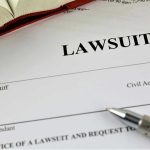 Backyard Game: Maine Family Files Wrongful-Death Lawsuit document with a pen and book.