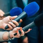 High Court Hands Daily Mail Sweeping Victory Reporters holding colorful microphones