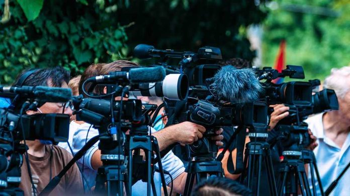default-hero-03-3 TV news cameras crowding together at an outdoor event