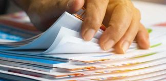 Hand sorting through a stack of colorful documents