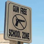 Gun-free school zone sign with crossed-out handgun symbol