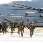 4,000 Troops Pullback Stuns Europe Soldiers disembark and walk past a large military helicopter