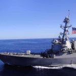 U.S. Sends Warships to Venezuela After Deadly Quakes Naval destroyer sailing on open sea with flag flying