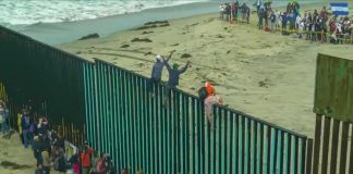 Ceuta Crisis Puts Spain on High Alert People climbing a tall beachside border fence