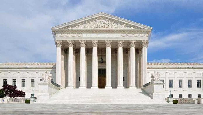 shutterstock_132568517-3 Front view of the Supreme Court building with large columns and steps under a blue sky