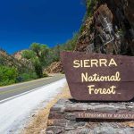 California Moves to Block Proposed Yosemite Land Swap Sierra National Forest roadside sign by winding mountain highway