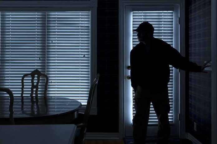 shutterstock_149341616 Silhouetted person in a dark room near a door with blinds