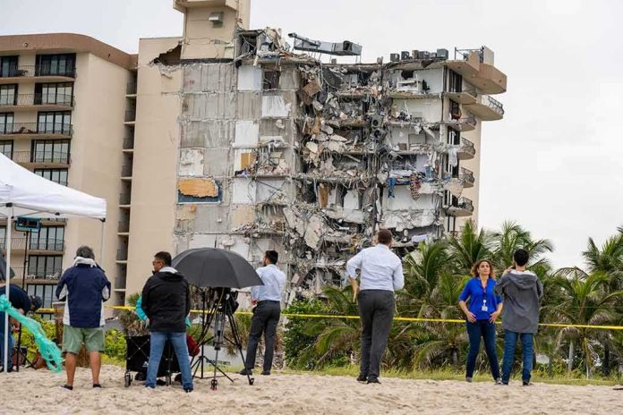shutterstock_1996559690 Partially collapsed beachfront apartment building with onlookers