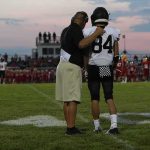 68-Game Winning Streak Comes to an End football coach with arm around player number 84 on sideline