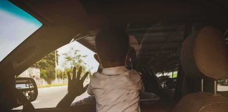 5-Year-Old Dies in Hot Car, Parents Charged Child leaning on car window from the back seat