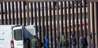 Gunpoint Kneeling Inside U.S.-Funded Detention Hotel Border agents escort a group near a tall fence and a patrol van
