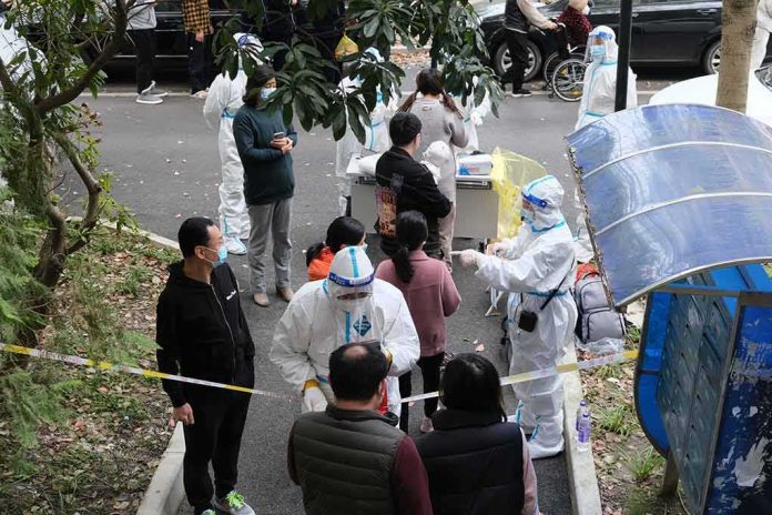 Christian Jones and others wait at an outdoor COVID-19 testing site with staff in protective suits