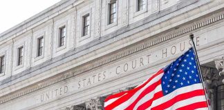 Judge Blocks FEMA Election Grant Conditions American flag waves in front of a United States courthouse facade