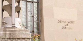 DOJ Charges 16 in Election Crime Cases Department of Justice building facade with stone sign and window