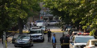 Ukraine’s Security Agencies Exchange Gunfire Police officers secure a residential street with patrol cars and yellow tape