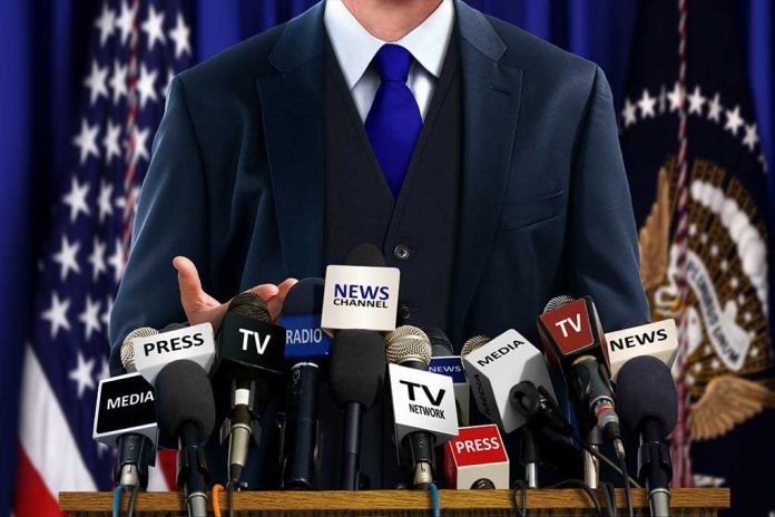 shutterstock_240517264 A speaker at a press conference with multiple microphones in front of them