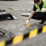 U.S. Consulate Shot Again, Suspect Still at Large Forensic investigator marking evidence at crash scene