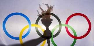 Olympic Flame Arrives in Dakar olympic rings with torch shadow