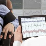 New Implant Creates Speech and Facial Expressions Technician reviews polygraph readings on a tablet beside a seated subject