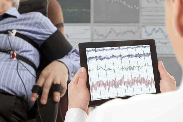 shutterstock_327795071-1 Technician reviews polygraph readings on a tablet beside a seated subject
