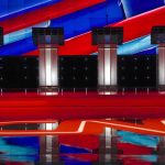 2028 Election Jibe Sparks Political Buzz Debate stage with four empty podiums and bright red and blue backdrop