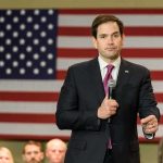 man in suit speaking into a microphone