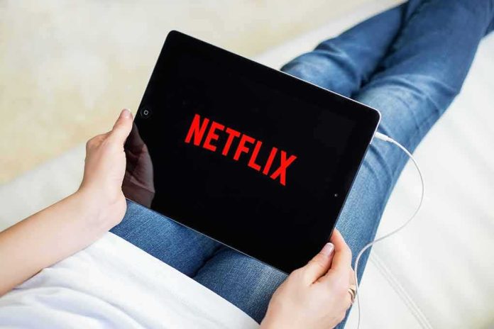 shutterstock_393295279-1 Person holding a tablet with streaming app on screen