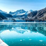U.S. Expands Military Access in Greenland Boat approaching a glacier in a turquoise fjord