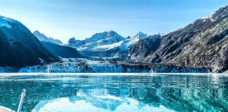U.S. Expands Military Access in Greenland Boat approaching a glacier in a turquoise fjord