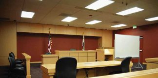 Head-of-State Immunity Challenged in U.S. Drug Case Interior view of an empty courtroom with wooden furniture and American flags