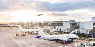 Midair Smoke Forces Emergency Landing Airplanes at airport gates during sunset with ground vehicles and jet bridges