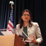 Jewish Clash: Michigan Meltdown Splits Democrats Rashida Tlaib speaking at a podium with a U.S. flag in the background